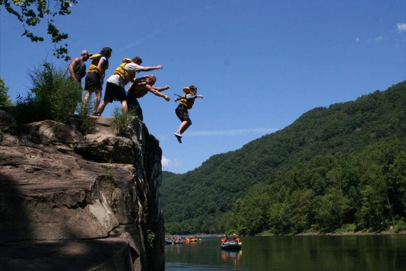 Swimmers leap into New River Swimmers at Jump Rock, Recreation on New River, Whitewater Rafting