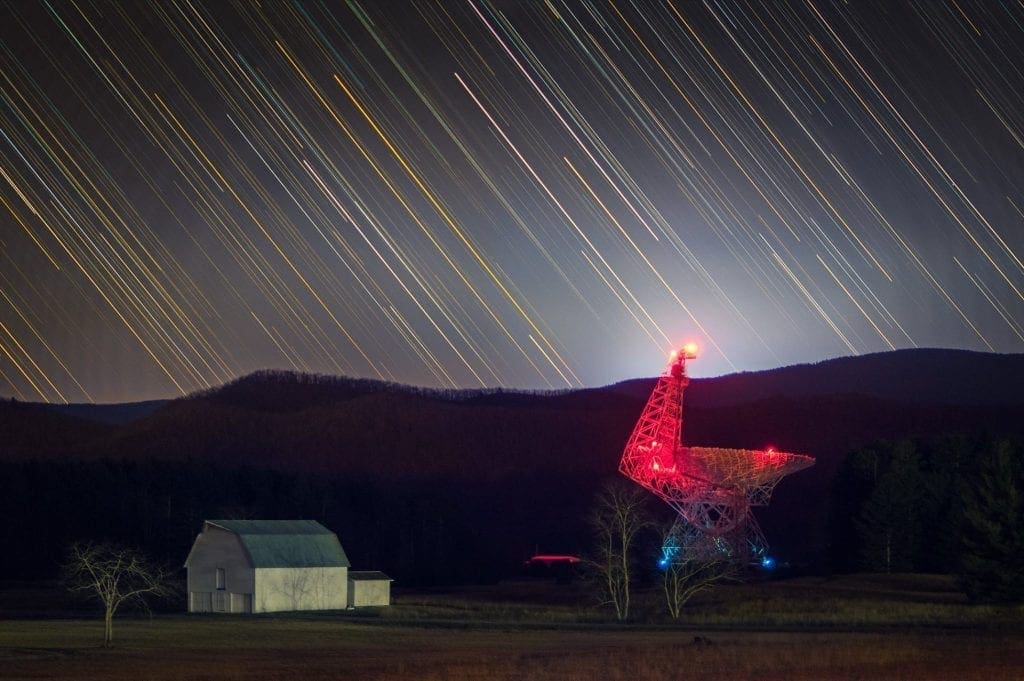 The Byrd Telescope glows red in the darkness at Green Bank.