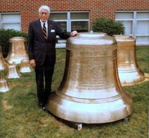 The late Dr. Marsh stands alongside the largest of bells that hang in the Concord University carillon.