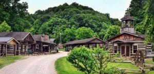 Log buildings collect along a gravel walk at the Heritage Farm Museum and Village near Huntington, West Virginia.