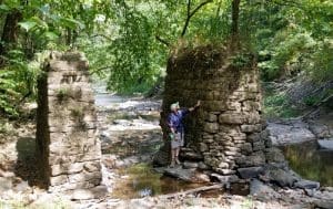 Justyn Marchese studies stone piers at the mouth of Lick Creek near the New RIver.