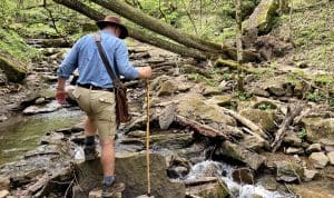 David Sibray picks his way across Big Branch, which can be too high to safely cross after a heavy rain.