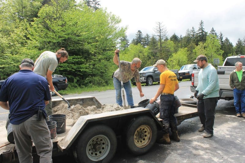Youth and W.Va. DNR staff fill buckets with limestone during a stream restoration project.
