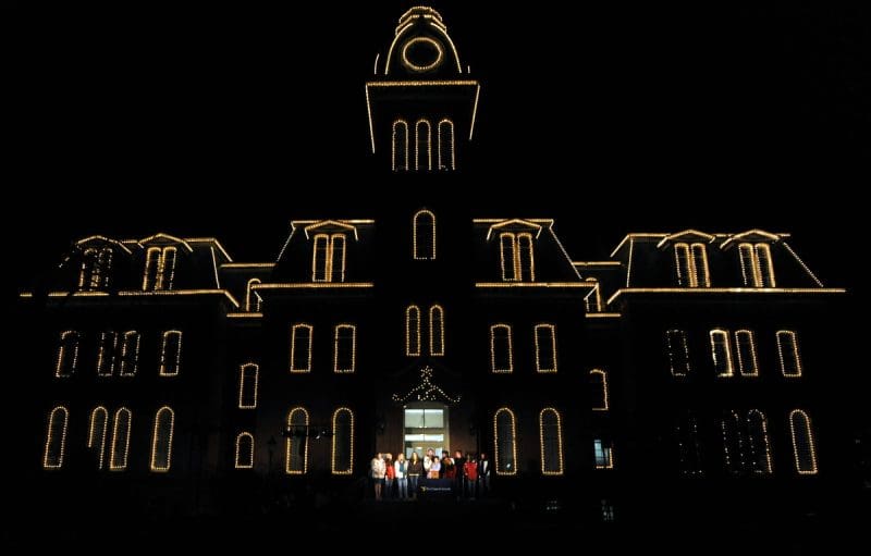 Woodburn Hall History: Holiday carolers sing outside the entrance to Woodburn Hall.